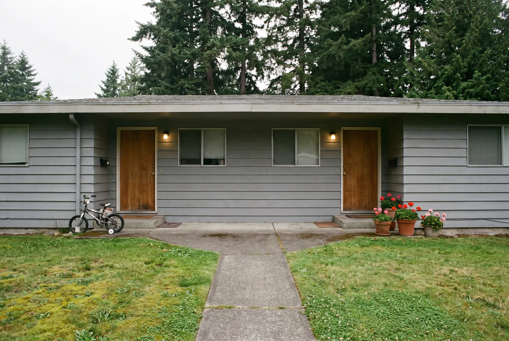 Illustration: a lived-in single-story duplex with two front doors, a bike by one and geraniums by the other