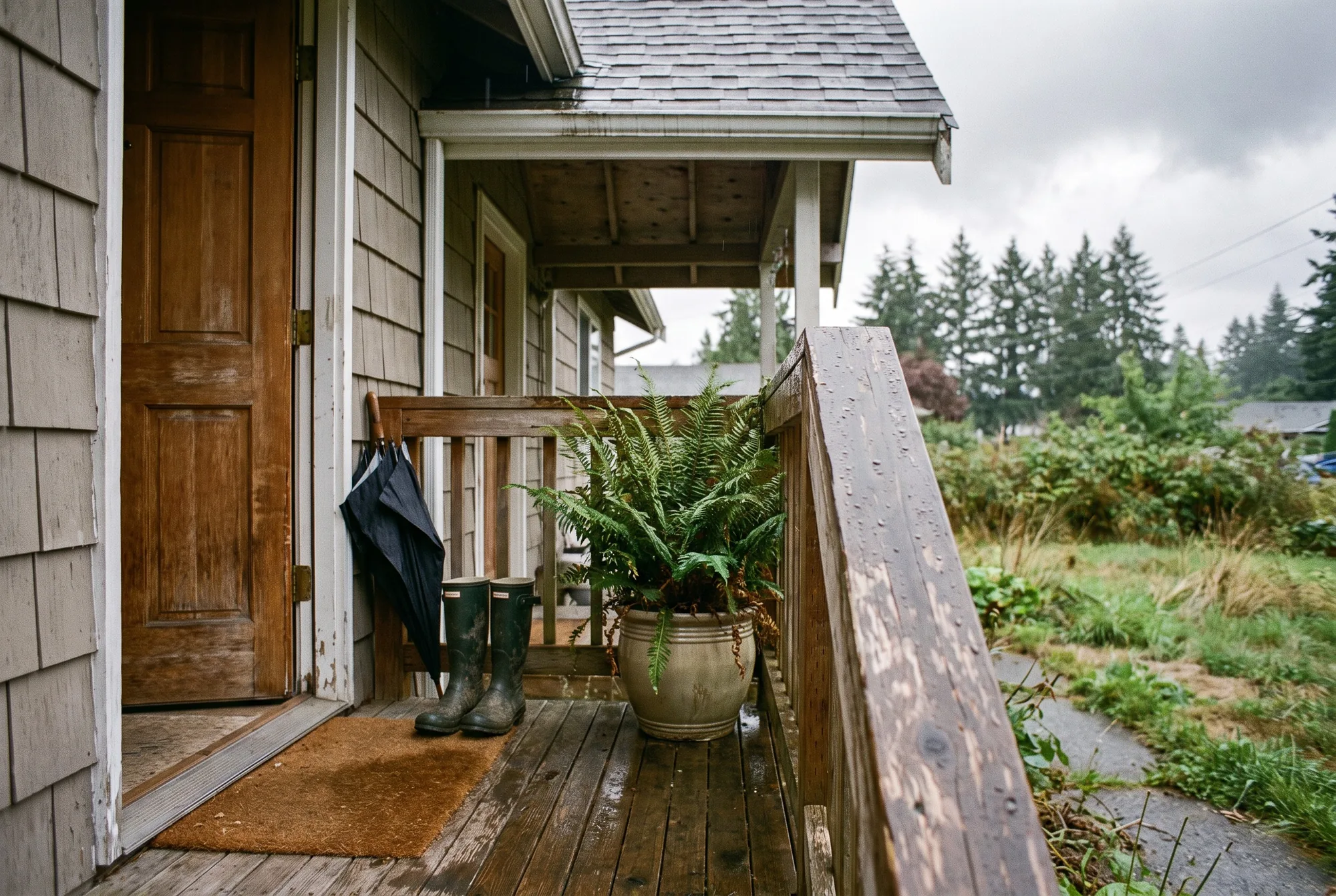 Illustration: the covered front porch of a rental house, rain boots and an umbrella by the door